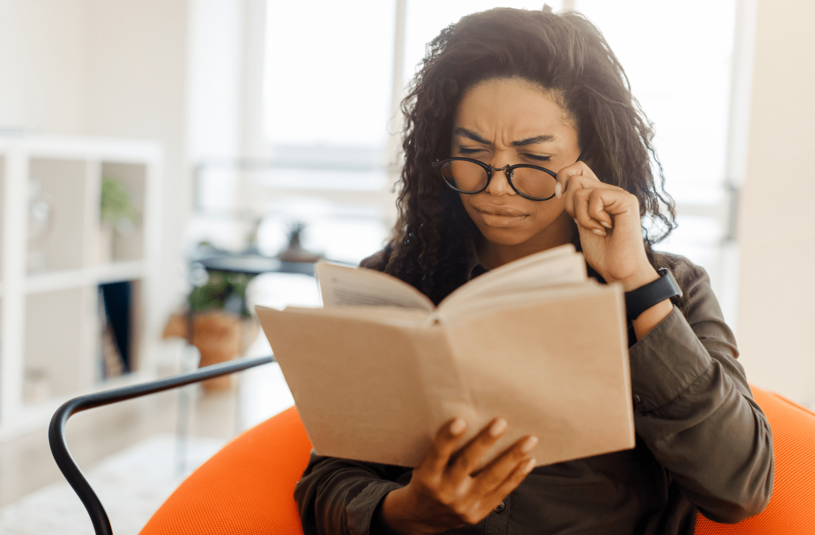 A woman having difficulty reading a book