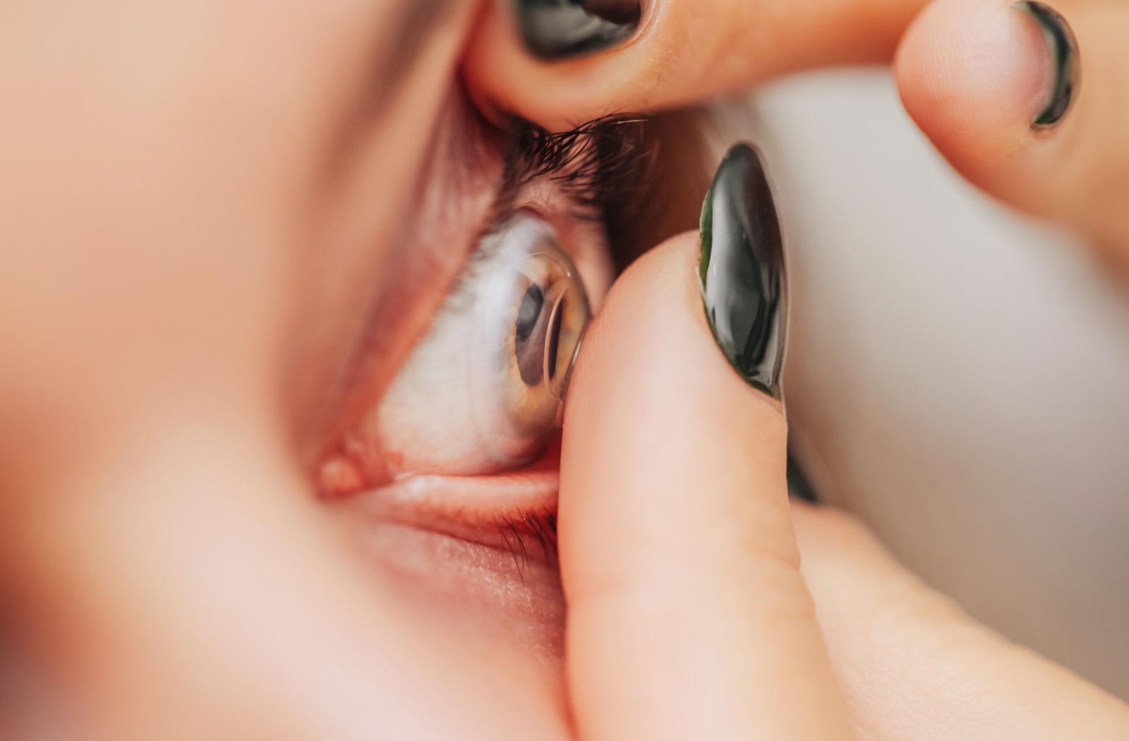 Close up of a person's eye as they insert a contact lens.