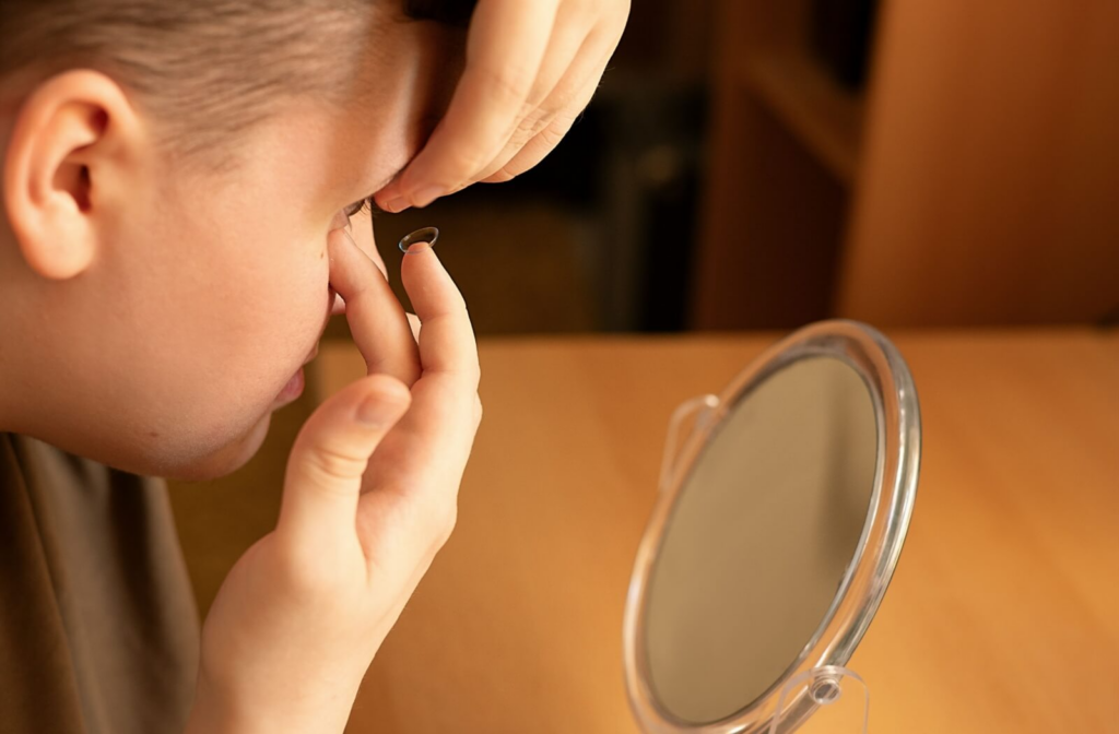 A child puts their daily disposable contact lens in their eye all by themselves.